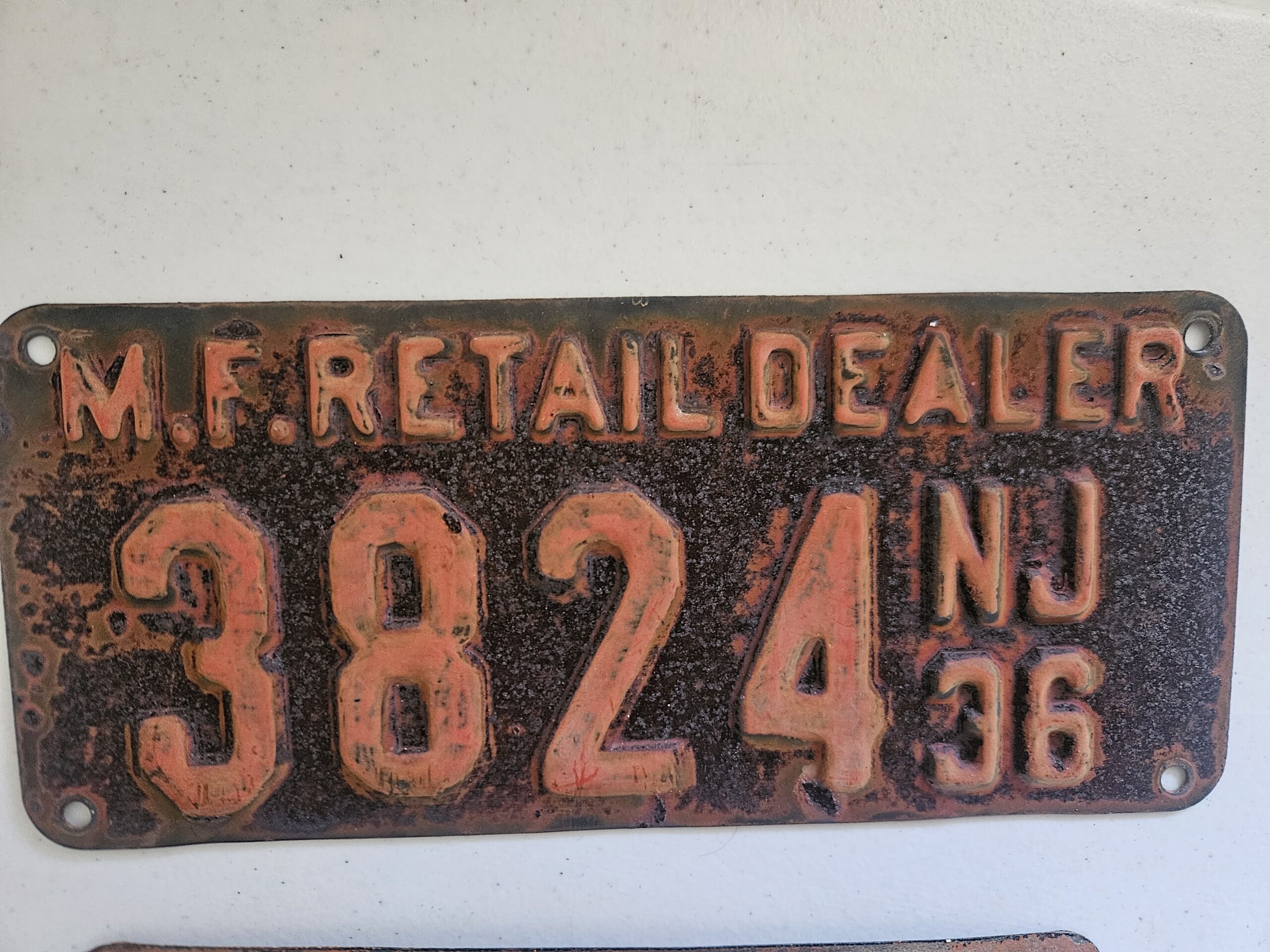 Weathered orange and black 1936 New Jersey motor fuel retail dealer license plate numbered 3824